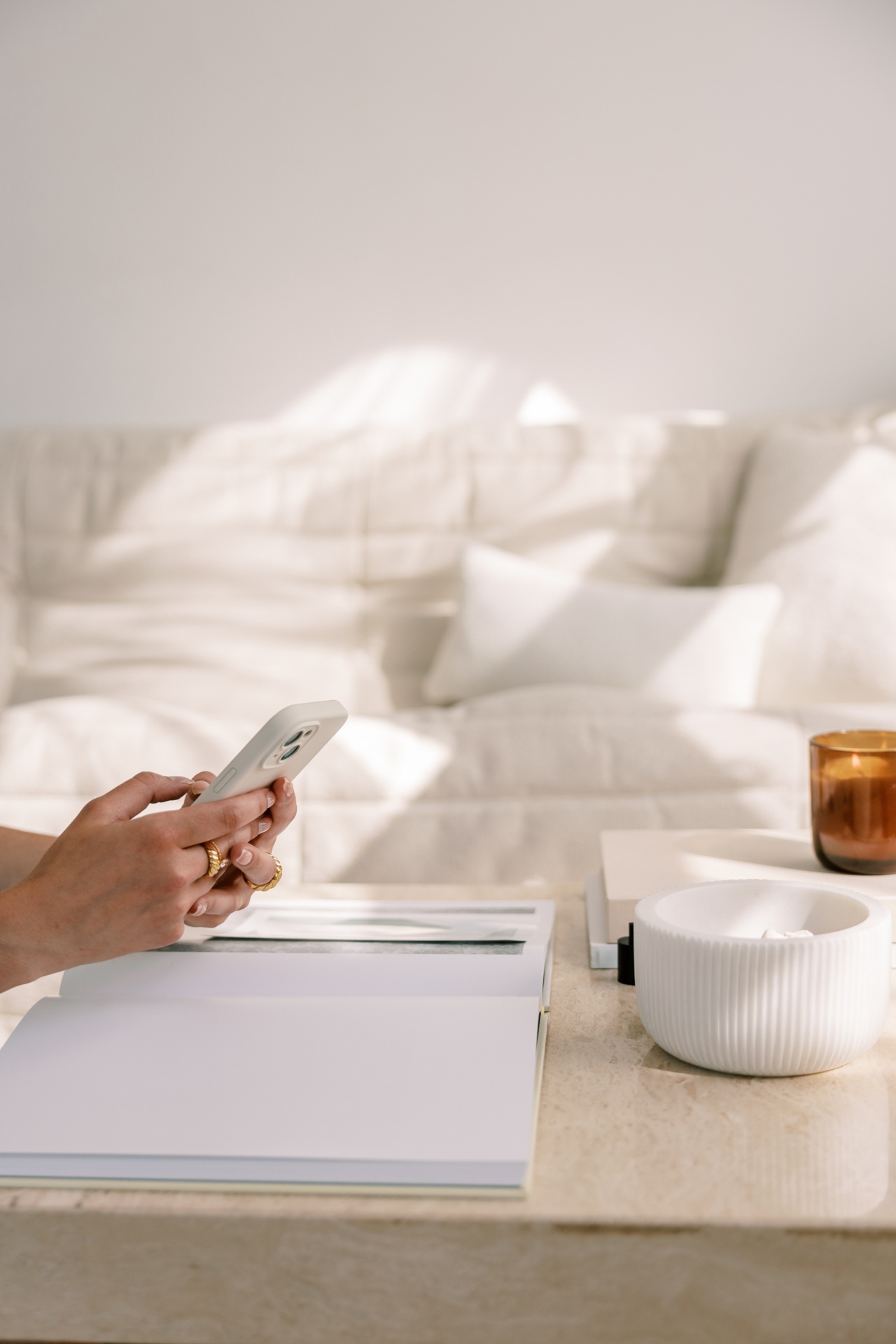 A woman journaling in warm natural light with tea and a coffee table book